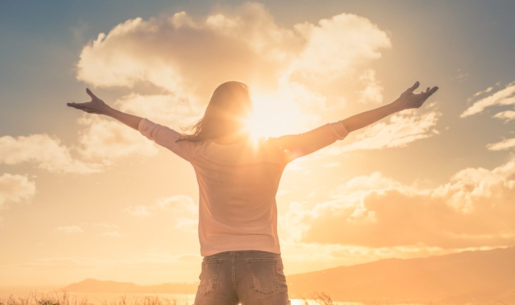 Person embracing sunlight with open arms – symbol of legal gender recognition and personal freedom through Gender Recognition Certificate services by NotaryPublic24.com